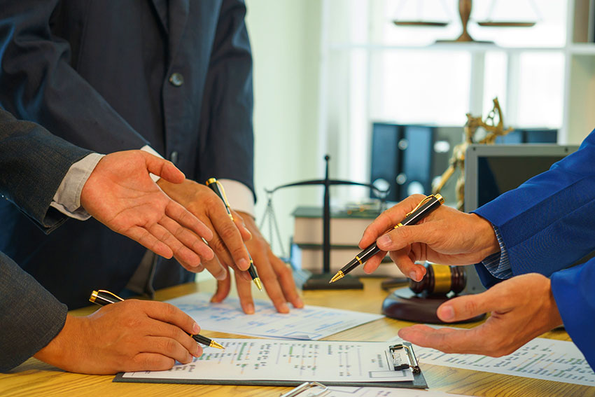 Civil-Litigation; A team of lawyers shares knowledge and discusses difficult cases. from one's conduct Lawyers reviewing court documents. Defendant, defense lawyer and relatives standing in the courtroom. African